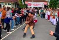 Para peserta lomba tarik tambang saling adu kekuatan di tengah kepungan penonton dalam semarak HUT RI yang pecah di halaman RSUD Mimika, Sabtu (8/8/2027). (Foto: Galeri Papua/Ahmad)