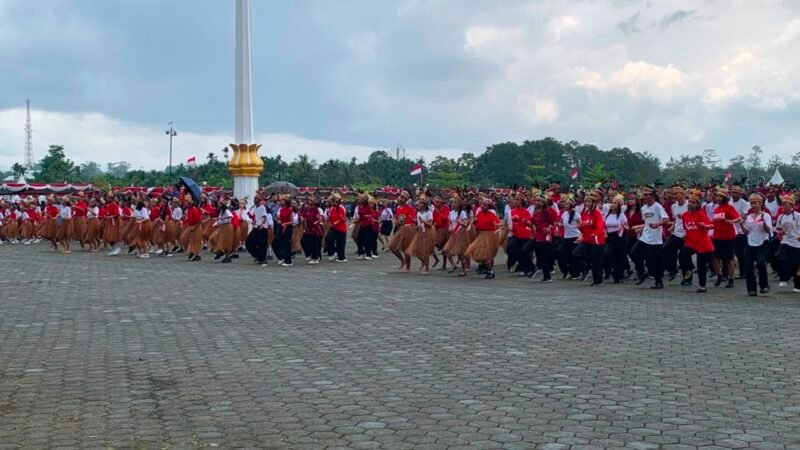 Ratusan siswa penari kolosal sedang membawakan tarian dua suku asli Mimika, Amungme dan Kamoro usai upacara pengibaran bendera merah putih di Lapangan Kantor Puspem Kabupaten Mimika, Senin (17/8/2026). (Foto: Galeri Papua/Ahmad)