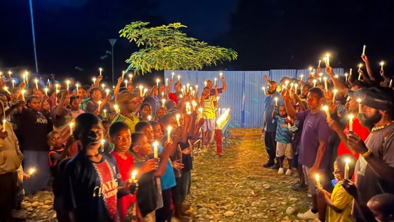 Puluhan warga Nduga menggelar ibadah dan menyalakan lilin di Kilometer 11, Mimika, Papua Tengah, pada Sabtu (22/8/2026). (Foto: Galeri Papua/Endy Langobelen)