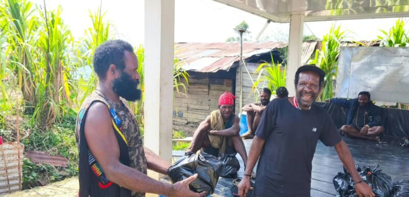 Nikolas Alome, Kepala Suku Damal Kabupaten Puncak, memberi bahan makan kepada masyarakat yang hadir pada saat sosialisasi. (Foto: Istimewa)