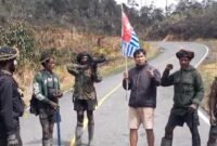 Seorang pria pendatang diminta mengangkat bendera bintang kejora dan menyerukan dukungan Papua merdeka oleh sekelompok orang bersenjata di salah satu ruas jalan di Kabupaten Jayawijaya, Papua Pegunungan, Selasa (15/9/2026). (Foto: Istimewa/Tangkapan layar video amatir)