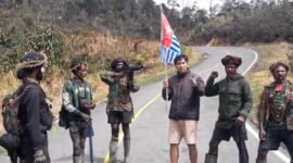 Seorang pria pendatang diminta mengangkat bendera bintang kejora dan menyerukan dukungan Papua merdeka oleh sekelompok orang bersenjata di salah satu ruas jalan di Kabupaten Jayawijaya, Papua Pegunungan, Selasa (15/9/2026). (Foto: Istimewa/Tangkapan layar video amatir)