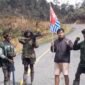 Seorang pria pendatang diminta mengangkat bendera bintang kejora dan menyerukan dukungan Papua merdeka oleh sekelompok orang bersenjata di salah satu ruas jalan di Kabupaten Jayawijaya, Papua Pegunungan, Selasa (15/9/2026). (Foto: Istimewa/Tangkapan layar video amatir)
