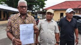 Bupati Mimika, Johannes Rettob, memperlihatkan surat laporan polisi yang ditujukan kepada Media Papua News Online. (Foto: Istimewa/Evan)