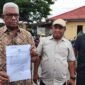 Bupati Mimika, Johannes Rettob, memperlihatkan surat laporan polisi yang ditujukan kepada Media Papua News Online. (Foto: Istimewa/Evan)