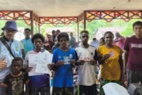 Foto bersama Kepala Bidang Pengelolaan Informasi Administrasi Kependudukan (PIAK) di Dinas Kependudukan dan Pencatatan Sipil (Dukcapil) Kabupaten Mimika, Amirullah dengan sejumlah warga yang telah menerima dokumen kependudukan usai menjalani perekaman data dan penerbitan dokumen kependudukan warga di Kampung Wumuka, Distrik Mimika Barat Tengah. (Foto: Istimewa)