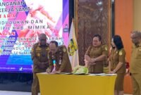 Kepala Disdukcapil Kabupaten Mimika, Slamet Sutejo, menandatangani perjanjian kerja sama. (Foto: Galeri Papua/Ahmad)