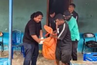 Aparat mengevakuasi jenazah korban dari dalam kamar kosnya. (Foto: Polres Mimika)