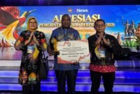 Pj Sekda Mimika Abraham Kateyau memegang penghargaan didampingi dua pejabat eselon di lingkungan Pemkab Mimika. (Foto: Pemkab Mimika)