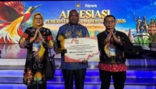 Pj Sekda Mimika Abraham Kateyau memegang penghargaan didampingi dua pejabat eselon di lingkungan Pemkab Mimika. (Foto: Pemkab Mimika)