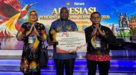 Pj Sekda Mimika Abraham Kateyau memegang penghargaan didampingi dua pejabat eselon di lingkungan Pemkab Mimika. (Foto: Pemkab Mimika)