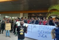 Sejumlah massa pemuda adat Papua membentangkan spanduk bertuliskan 
