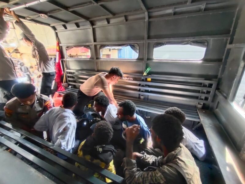 Aparat kepolisian mengamankan enam peserta aksi Solidaritas Pelajar West Papua (SPWP) ke dalam mobil Dalmas Polresta Jayapura Kota setelah membubarkan paksa demonstrasi penolakan program Makan Bergizi Gratis di kawasan Perumnas Tiga, Waena, Jayapura, Selasa, 15 September 2026. Galeripapua/Ikbal Asra