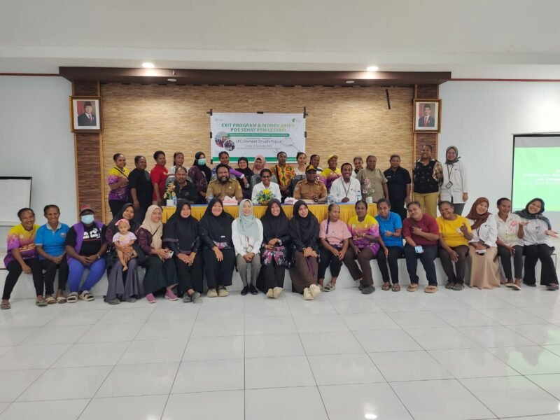 Sekretaris Pemerintah Kampung Holtekamp Elke Elisabeth (tengah) bersama Koordinator LKC Dompet Dhuafa Papua Tumijan (kanan), perwakilan Dinas Kesehatan Kota Jayapura, perwakilan Puskesmas Koya Barat, kader posyandu, dan warga peserta program berfoto bersama dalam acara exit program Pos Sehat PTM Lestari di balai Kampung Holtekamp, Jayapura, Papua, Selasa, 22 September 2026. Galeripapua/ Ikbal Asra.