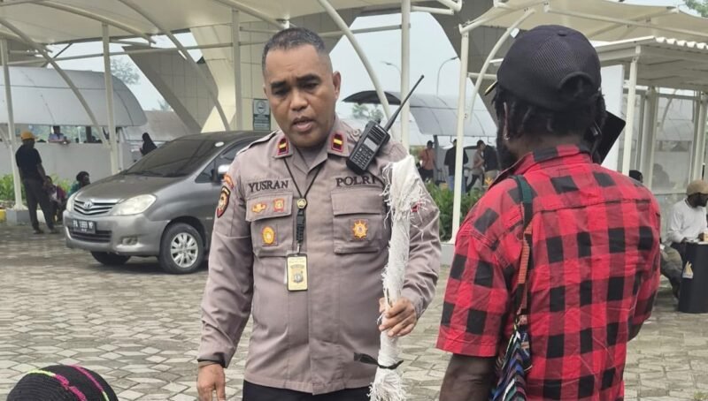 Kapolsek Kawasan Bandara Mozes Kilangin Timika, Ipda Yusran Jaya Milu saat memegang anak panah dari penumpang pesawat usai disita oleh personel Polsek Kawasan Bandara Mozes Kilangin Timika. (Foto: Istimewa)