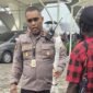 Kapolsek Kawasan Bandara Mozes Kilangin Timika, Ipda Yusran Jaya Milu saat memegang anak panah dari penumpang pesawat usai disita oleh personel Polsek Kawasan Bandara Mozes Kilangin Timika. (Foto: Istimewa)