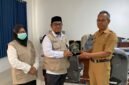 Kepala Kantor Kemenhaj Kabupaten Jayawijaya, Abdul Sakir (kiri), menyerahkan plakat kepada Plt. Sekda Kabupaten Jayawijaya, Tinggal Wusono, saat melakukan audiensi mengenai integrasi data jemaah haji di Jayawijaya, Senin (12/10/2026). (Foto: Dok. Kemenhaj Jayawijaya)