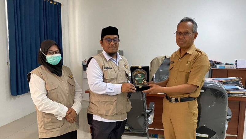 Kepala Kantor Kemenhaj Kabupaten Jayawijaya, Abdul Sakir (kiri), menyerahkan plakat kepada Plt. Sekda Kabupaten Jayawijaya, Tinggal Wusono, saat melakukan audiensi mengenai integrasi data jemaah haji di Jayawijaya, Senin (12/10/2026). (Foto: Dok. Kemenhaj Jayawijaya)