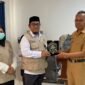 Kepala Kantor Kemenhaj Kabupaten Jayawijaya, Abdul Sakir (kiri), menyerahkan plakat kepada Plt. Sekda Kabupaten Jayawijaya, Tinggal Wusono, saat melakukan audiensi mengenai integrasi data jemaah haji di Jayawijaya, Senin (12/10/2026). (Foto: Dok. Kemenhaj Jayawijaya)
