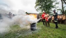 Seorang siswa didampingi seorang Rescuer sedang memperagakan langsung teknik memadamkan api dengan menggunakan APAR, bertempat di lapangan SMA Negeri 1 Mimika, Jumat (23/10/2026). (Foto: Galeri Papua/Fernando Rio)