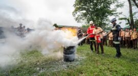 Seorang siswa didampingi seorang Rescuer sedang memperagakan langsung teknik memadamkan api dengan menggunakan APAR, bertempat di lapangan SMA Negeri 1 Mimika, Jumat (23/10/2026). (Foto: Galeri Papua/Fernando Rio)